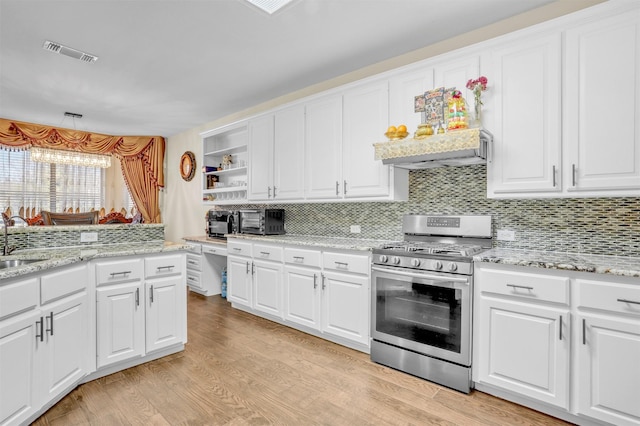 kitchen with stainless steel gas range oven, visible vents, white cabinetry, light wood-type flooring, and open shelves