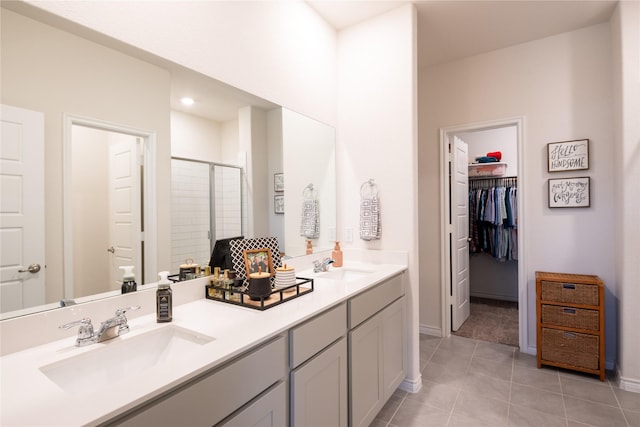 bathroom with double vanity, a stall shower, a sink, and tile patterned floors