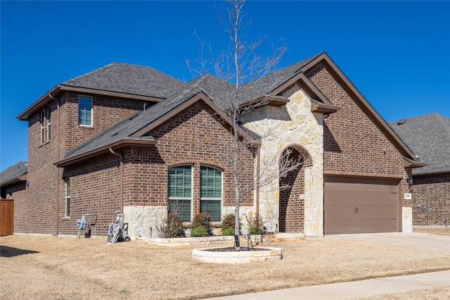 french provincial home featuring stone siding, brick siding, and concrete driveway