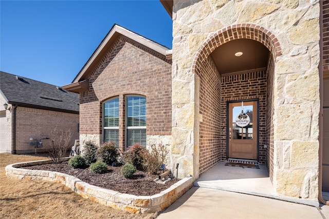 property entrance featuring stone siding and brick siding