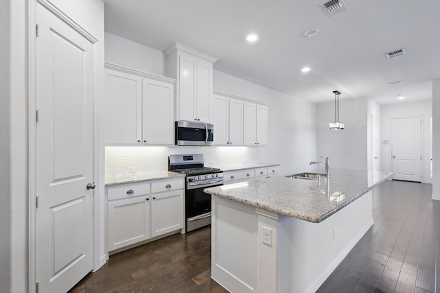 kitchen with dark wood finished floors, stainless steel appliances, visible vents, white cabinetry, and a sink