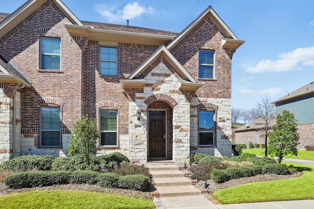 french country inspired facade featuring stone siding and brick siding