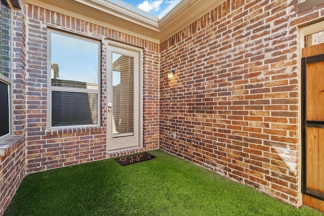 property entrance featuring brick siding