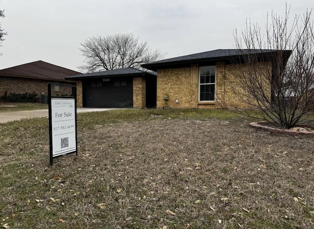 view of front of property with a garage and brick siding