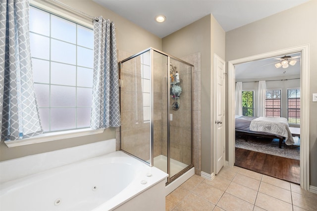 ensuite bathroom featuring tile patterned floors, connected bathroom, a shower stall, baseboards, and a tub with jets