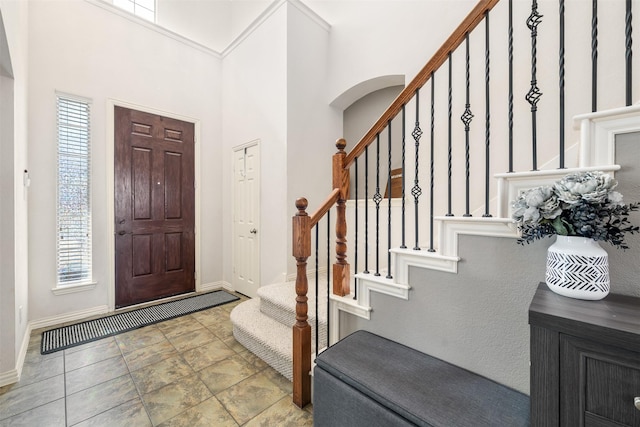 foyer entrance with a high ceiling and baseboards