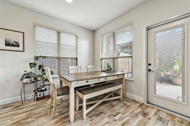 dining area with light wood-type flooring and baseboards