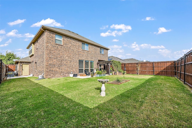 rear view of house featuring a yard, a fenced backyard, and brick siding