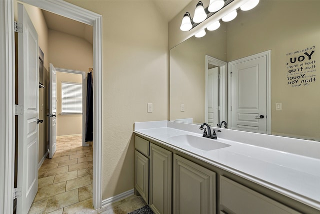 bathroom featuring a chandelier, vanity, and baseboards