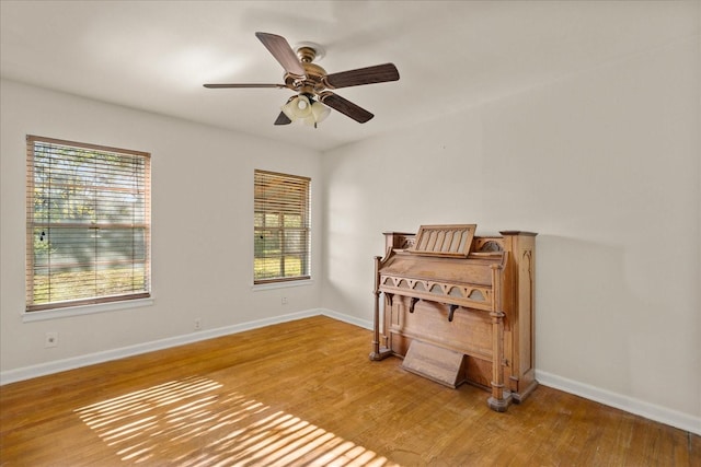 interior space featuring ceiling fan, wood finished floors, and baseboards