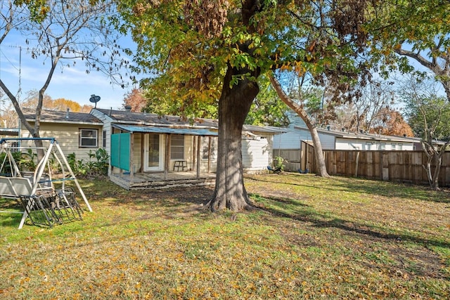 back of house featuring a yard and fence