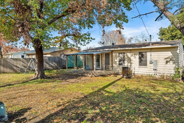 rear view of property with a yard and fence