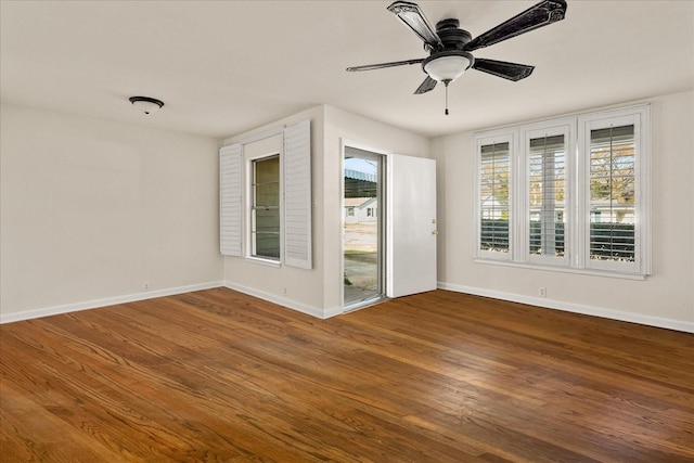 spare room with ceiling fan, wood finished floors, and baseboards