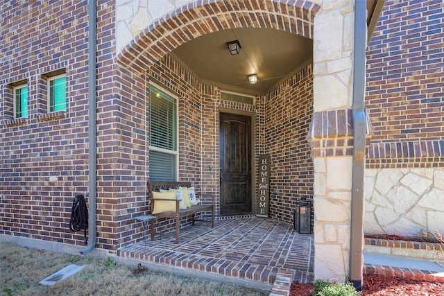 view of exterior entry featuring brick siding