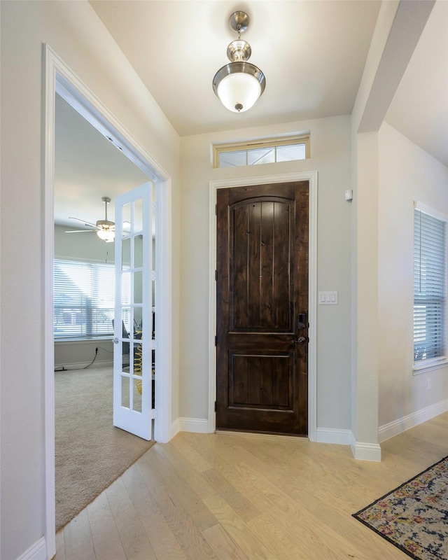 entrance foyer featuring french doors, baseboards, and light wood finished floors