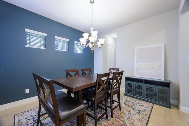 dining area with a notable chandelier, baseboards, and wood finished floors