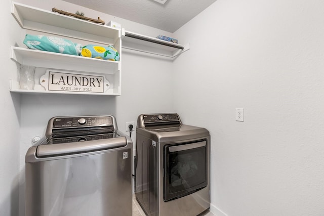 laundry area featuring laundry area, a textured ceiling, and separate washer and dryer