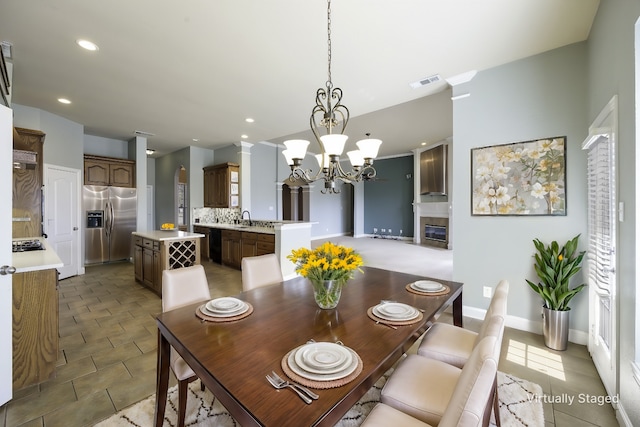 dining area featuring a glass covered fireplace, visible vents, recessed lighting, and an inviting chandelier