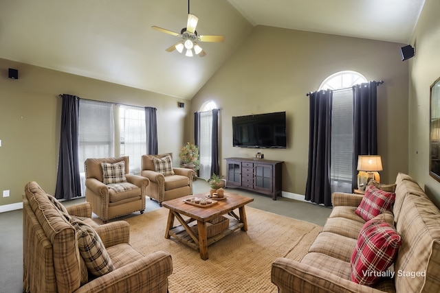 living area with baseboards, high vaulted ceiling, a ceiling fan, and light colored carpet