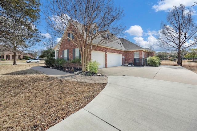 view of front of house featuring brick siding, roof with shingles, concrete driveway, fence, and a garage