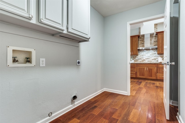 washroom with hookup for a washing machine, hookup for an electric dryer, dark wood-type flooring, baseboards, and cabinet space