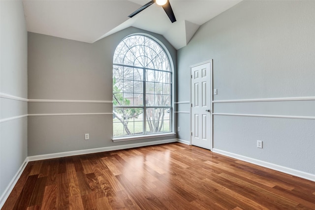 spare room featuring vaulted ceiling, ceiling fan, wood finished floors, and baseboards