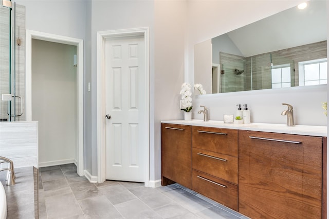 full bathroom featuring double vanity, an enclosed shower, a sink, and baseboards