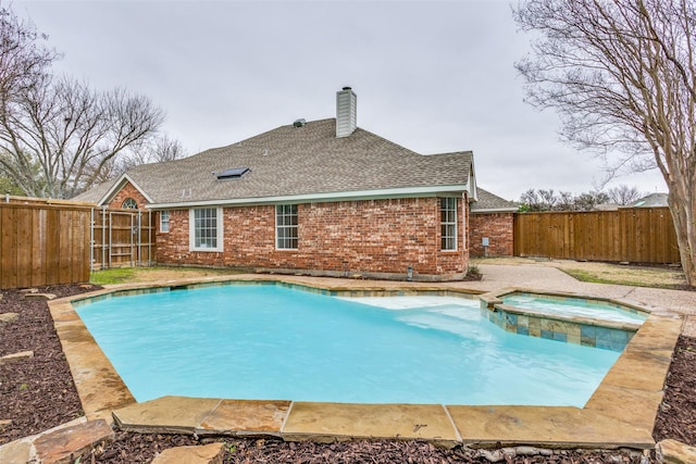 view of pool with a pool with connected hot tub and a fenced backyard