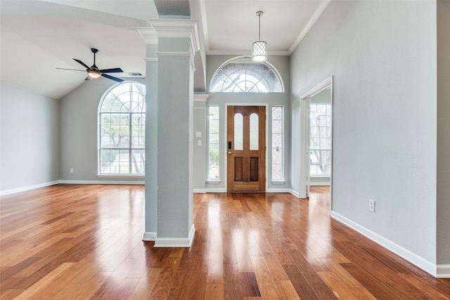 entrance foyer with ornamental molding, wood finished floors, a wealth of natural light, and baseboards