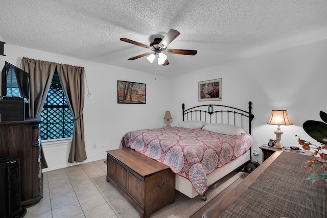 bedroom featuring a textured ceiling, ceiling fan, light tile patterned floors, and baseboards