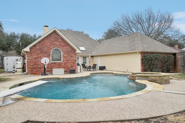 view of swimming pool featuring a pool with connected hot tub and a patio