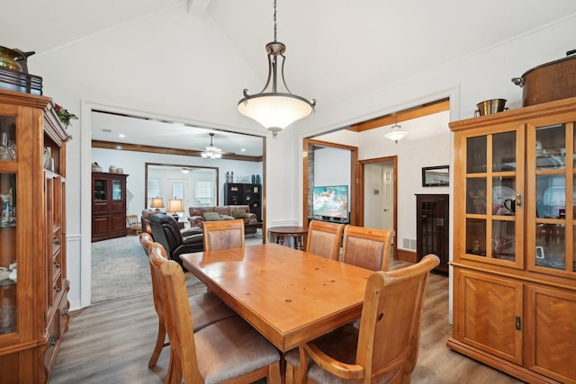 dining space with beam ceiling, high vaulted ceiling, and wood finished floors