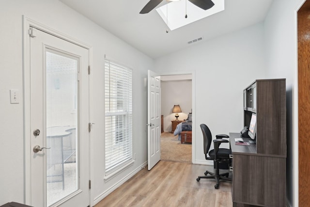 home office featuring visible vents, baseboards, lofted ceiling, ceiling fan, and light wood-style floors