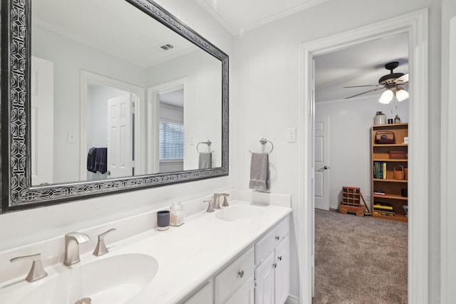 bathroom with crown molding, a sink, ceiling fan, and double vanity