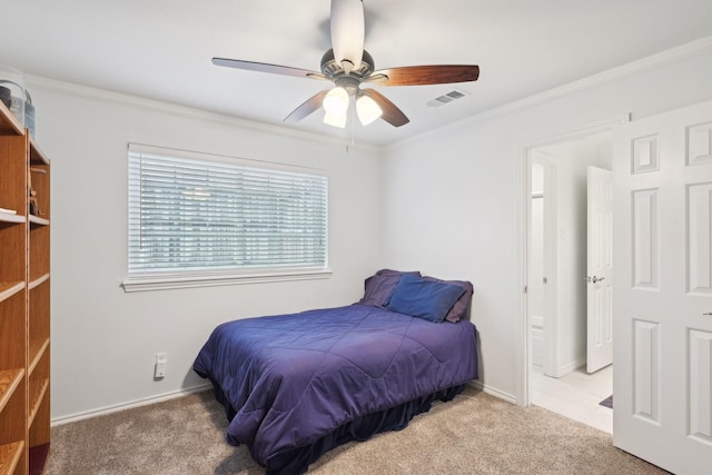 carpeted bedroom featuring baseboards, a ceiling fan, visible vents, and crown molding