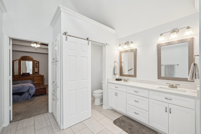 bathroom featuring double vanity, ensuite bath, a sink, and toilet