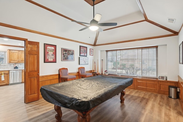 recreation room featuring lofted ceiling, light wood-style flooring, visible vents, wainscoting, and crown molding