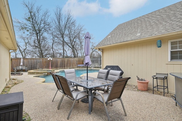 view of patio with a fenced backyard, a pool with connected hot tub, and outdoor dining space