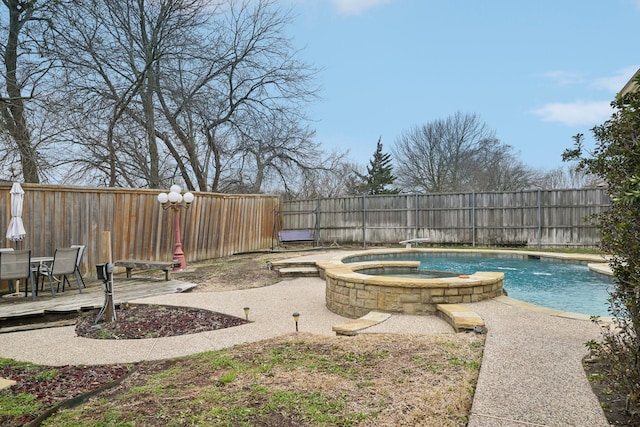 view of swimming pool featuring a fenced backyard and a pool with connected hot tub