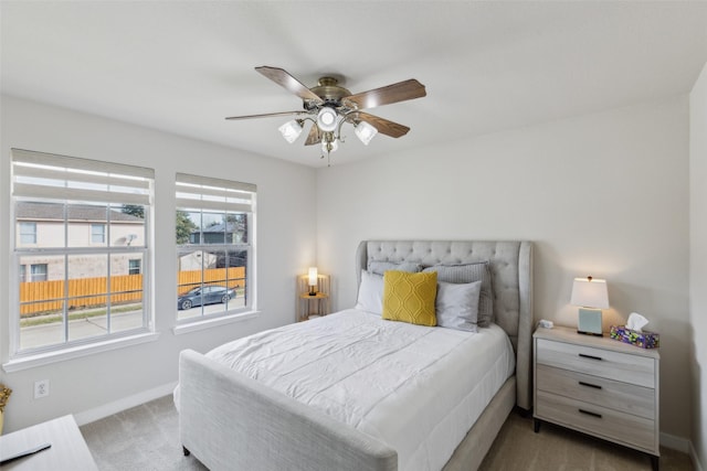 bedroom featuring a ceiling fan, carpet, multiple windows, and baseboards