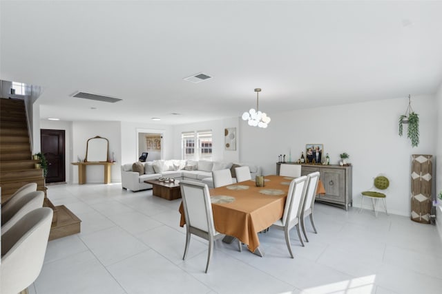 dining room with a chandelier, stairway, light tile patterned flooring, and visible vents