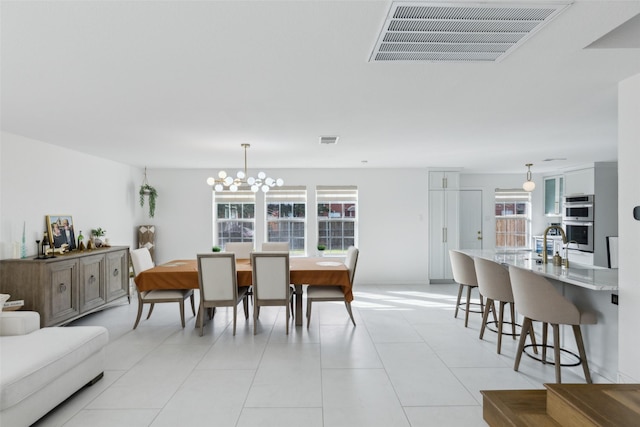 dining area featuring visible vents, an inviting chandelier, and light tile patterned floors