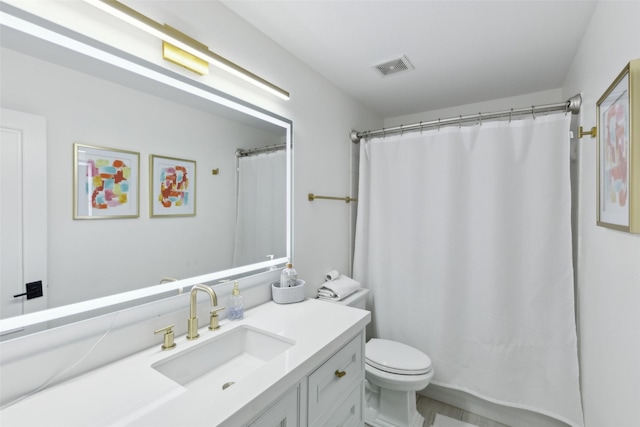 bathroom featuring a shower with shower curtain, visible vents, vanity, and toilet