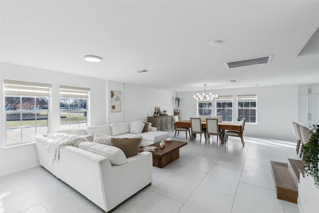 living area with a chandelier, visible vents, and light tile patterned floors