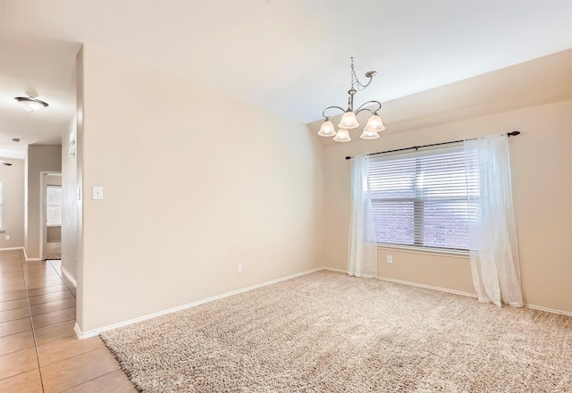 spare room featuring an inviting chandelier, light tile patterned floors, and baseboards