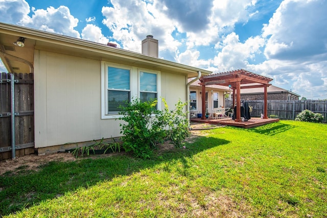 back of house featuring a yard, a chimney, a pergola, a fenced backyard, and a wooden deck