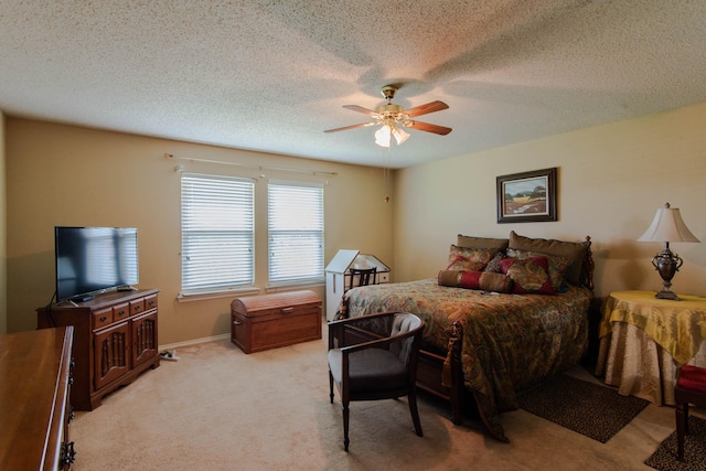 bedroom featuring ceiling fan, a textured ceiling, baseboards, and light colored carpet