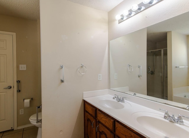 bathroom with a shower stall, a textured ceiling, a sink, and tile patterned floors