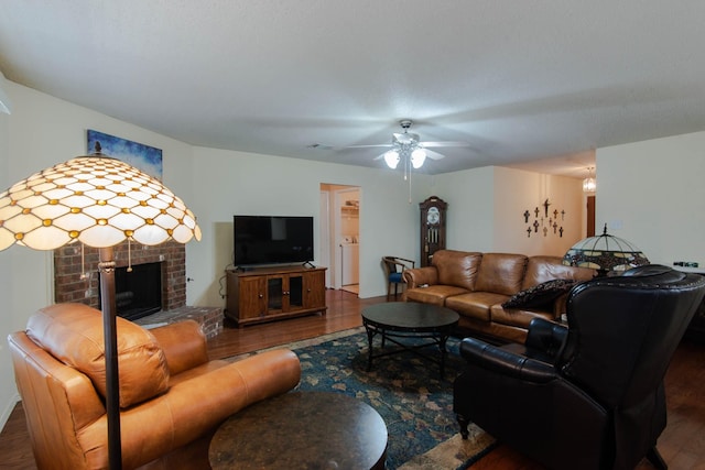 living room with ceiling fan, a fireplace, wood finished floors, and visible vents