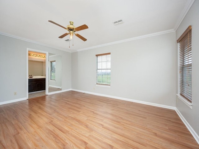 unfurnished room with light wood-style flooring, visible vents, baseboards, and ornamental molding